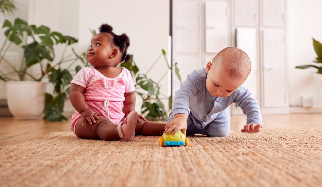 Baby boy and girl playing with toys.
